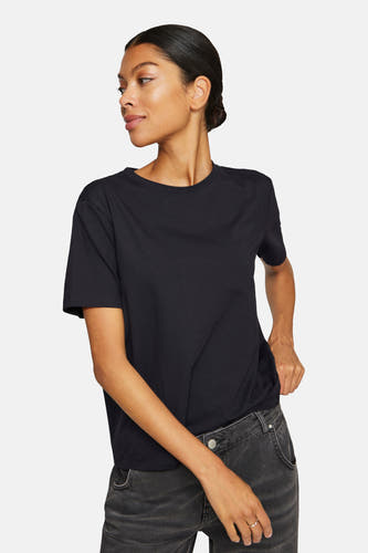 T-shirt noir à manches courtes de VILA®, porté avec un jean gris et rentré de manière décontractée.