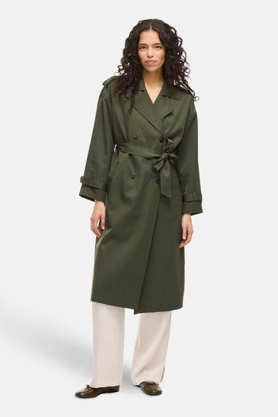 Veste verte de VILA®, avec une ceinture à boutons et portée sur un pantalon crème.