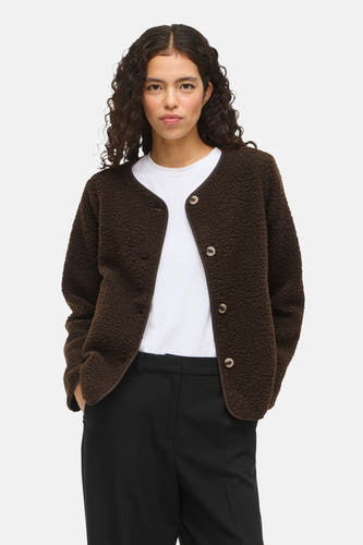 Manteau court brun de VILA®, avec fermeture à boutons et un T-shirt blanc en dessous.