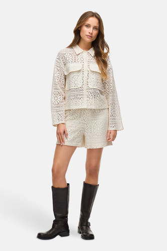 Chemise écru à manches longues de VILA®, avec des détails en dentelle et portée avec des shorts coordonnés et des bottes noires.