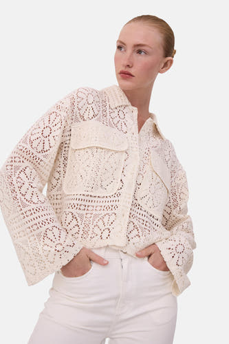 Blouse écru à manches longues de VILA®, avec un motif crocheté et des poches broiquées, associée à une culotte blanche.