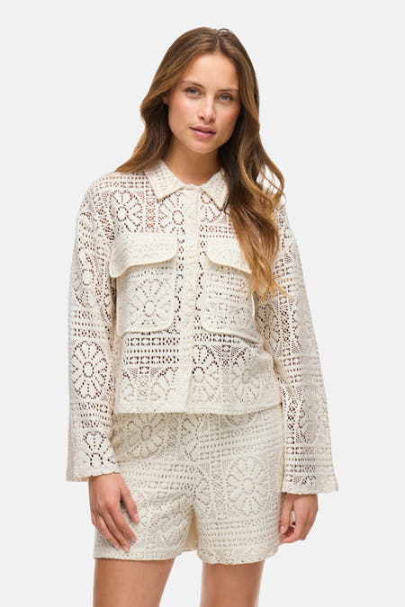 Chemise écru de VILA, avec des manches longues, un motif de fleurs tricoté ouvert et deux poches poitrine.