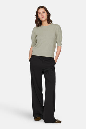 T-shirt vert de mantes courtes V V V, avecé une pantalon noir et des chaussures plates.