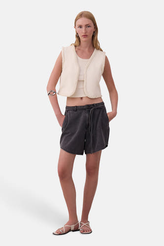 Short gris de VILA, avec une taille haute et une ceinture élastiquée, combiné à un top et un gilet.