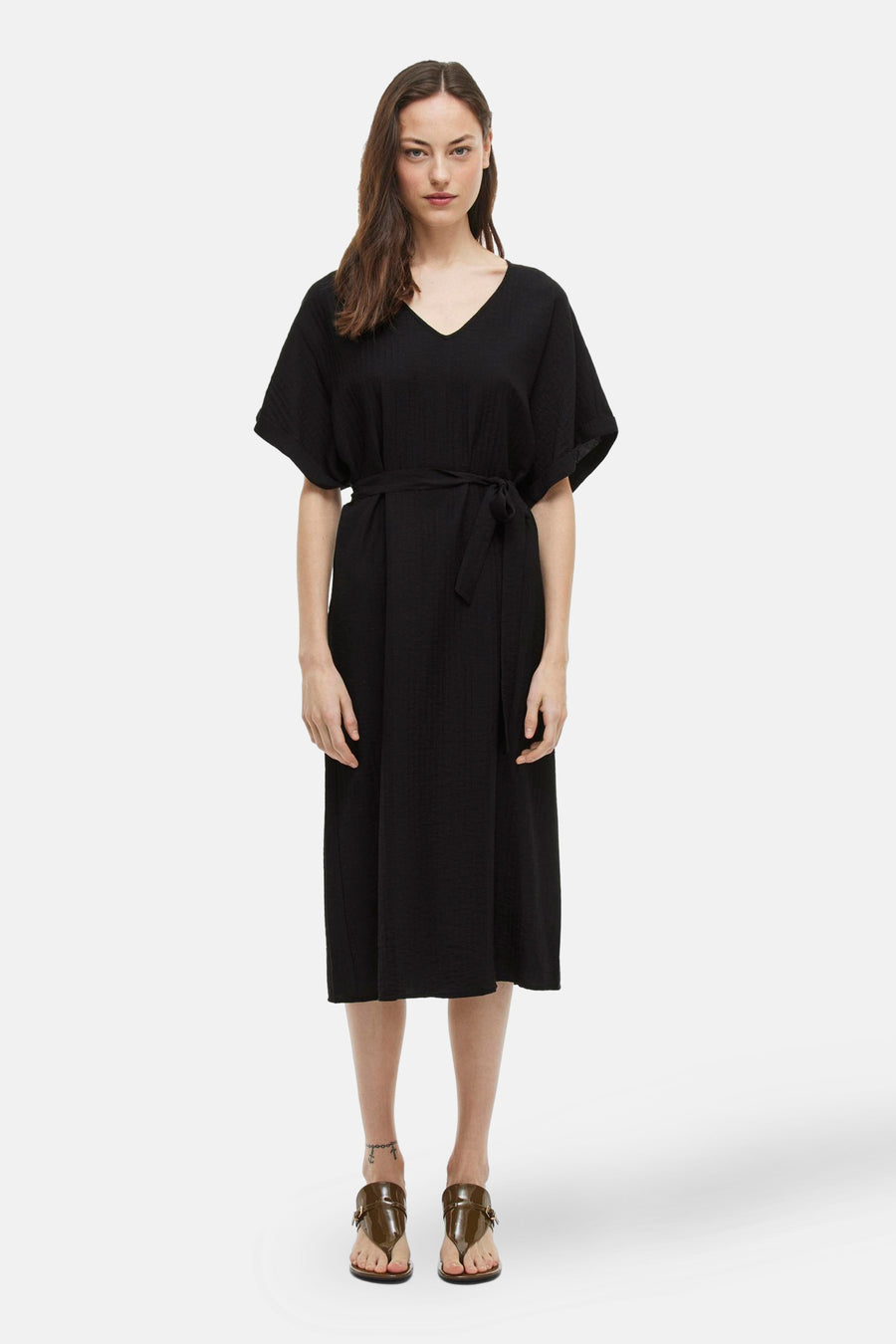Robe noire à manches courtes de VILA®, avec une ceinture et des sandales.