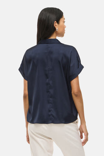 Blouse bleue à manches courtes de VILA, vue de derrière, avec un col et un pantalon beige.