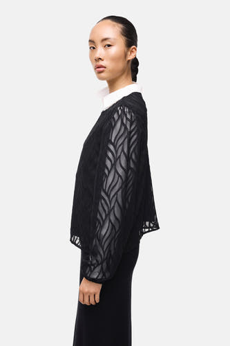 Blouse noire à manches longues de VILA, avec un col blanc et un motif décoratif transparent.