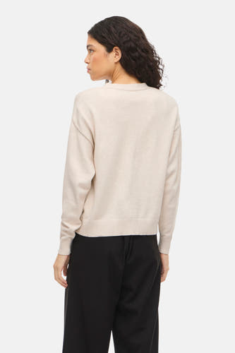 Cardigan écru de VILA à manches longues, combiné avec un pantalon noir, vu de dos.