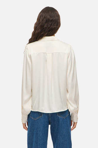 Blouse blanche à manches longues de VILA®, vue de derrière, associée à un jean bleu.