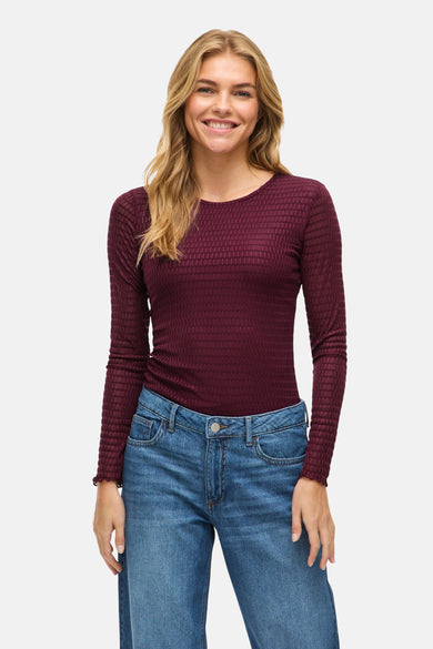 T-shirt marron à manches longues de VILA® avec une texture tissée et porté avec des jeans bleus.