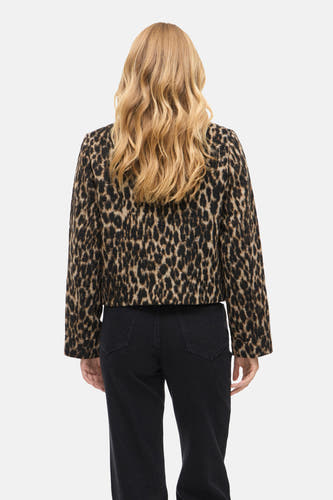 Manteau court brun de VILA® avec imprimé léopard, visible sur le dos, associé à une jupe noire.