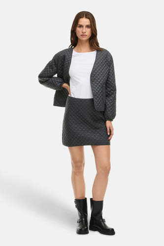 Jupe courte noire de VILA, avec un motif à carreaux froissé et associée à une veste et des bottes.