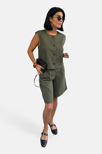 Gilet vert de VILA, gedragen met passende shorts en zwarte sandalen met studded.