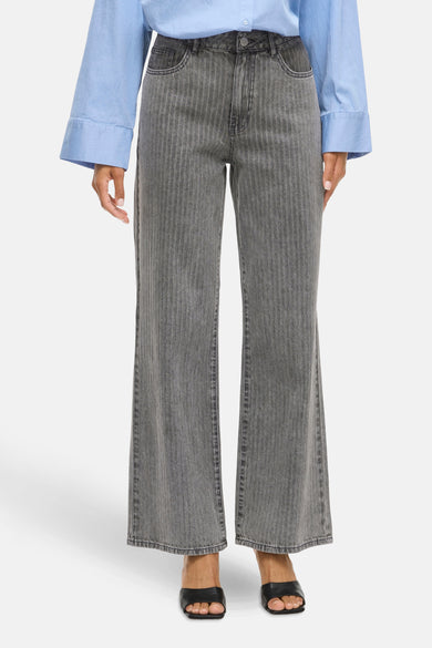 Jean denim gris clair large de Vila, avec des rayures verticales et une chemise bleue.