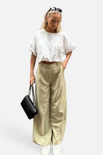 Jean vert de VILA®, avec des jambes larges, des poches et porté avec un crop top blanc et des baskets blanches.