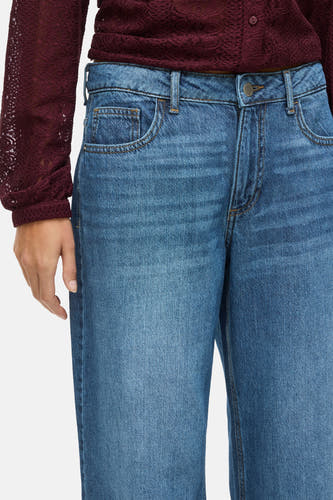 Jean en denim bleu de VILA, avec des jambes larges et des poches et un bouton visible.