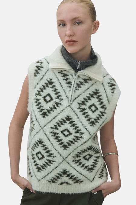 T-shirt écru de VILA, avec un motif à carreaux tricoté et une encolure à fermetures éclair, porté sur une chemise grise.