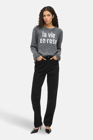 Sweat-shirt gris à col rond de VILA®, avec le texte "la vie en rose", associé à un jean noir et des baskets.