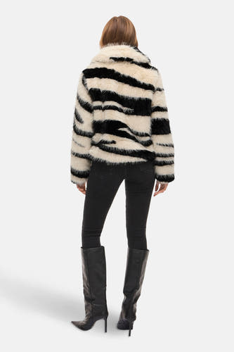 Manteau multicolore court de VILA®, avec un motif rayé noir et blanc, porté avec des jeans noirs et des bottes.