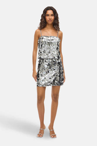 Robe courte en argent de VILA, recouverte de paillettes scintillantes et associée à des talons en argent.