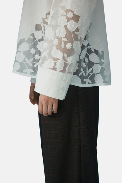 Blanc, t-shirt à longues manches de VILA®, avec des détails de fleurs sur les manches et un short à carreaux marron.