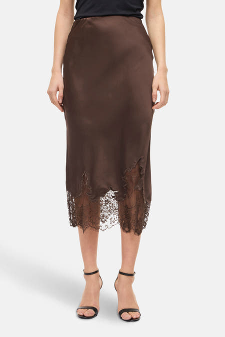 Jupe brune de VILA®, avec une bordure sur les bords inférieurs, associée à une chemise noire et des sandales noires à talon.