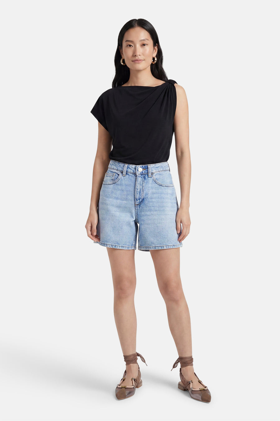 Lichtblauwe denim short van VILA® met hoge taille en voorzakken, gecombineerd met een zwart topje en platte schoenen.
