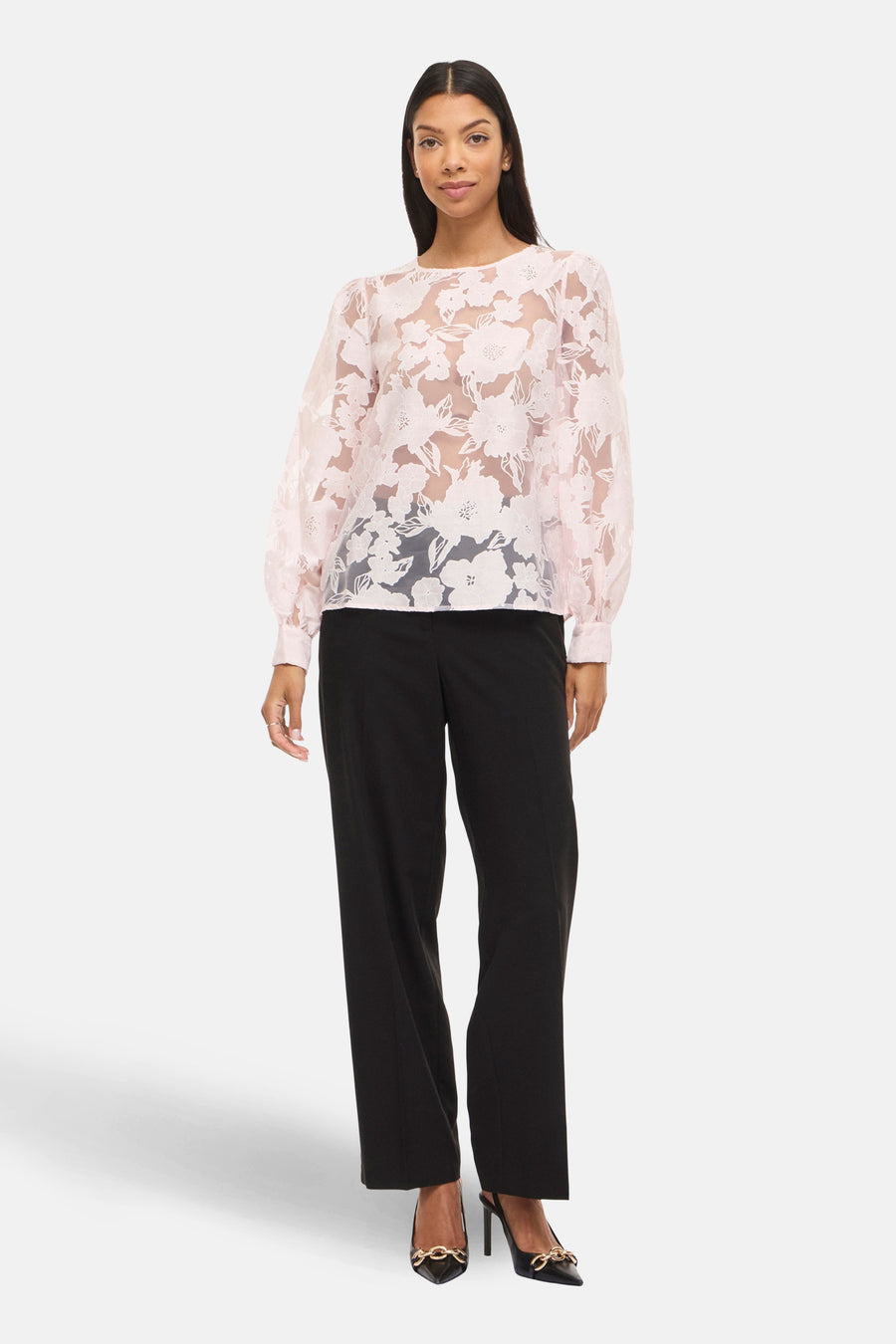 Roze blouse met lange mouwen van VILA®, met bloemenpatroon en gecombineerd met een zwarte pantalon en hoge hakken.
