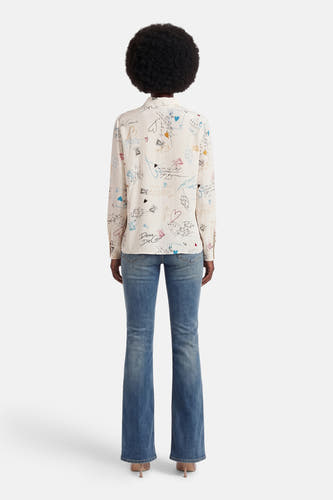 Chemise multicolore à manches longues de VILA, avec des cœurs ludiques et des motifs de cartes. Porté avec un jean et des talons.