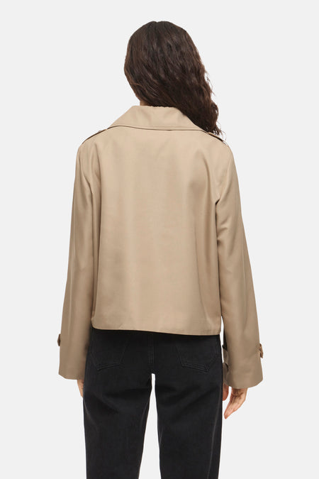 Manteau court beige de VILA® à manches longues, vu de dos, combiné avec un jean noir.