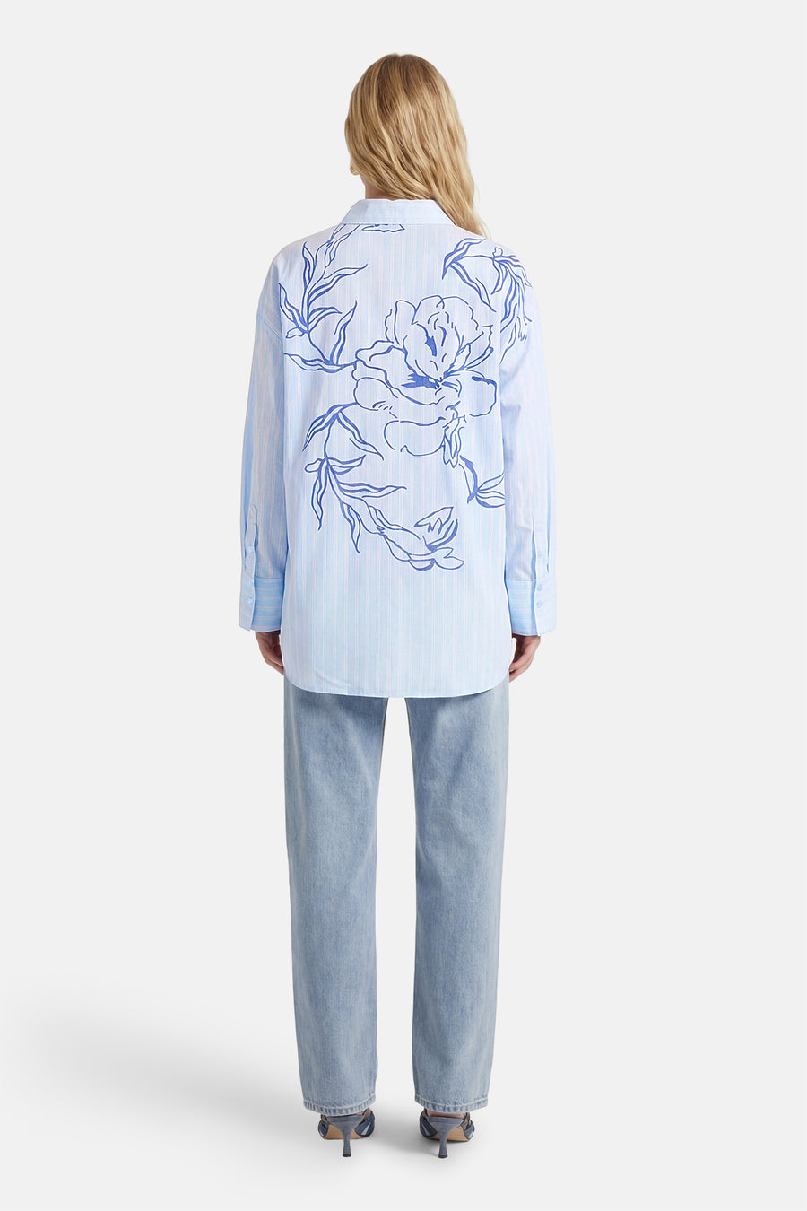 Chemise bleue à rayures à manches longues de VILA, avec un grand imprimé floral dans le dos, à combiner avec un jean et des talons.