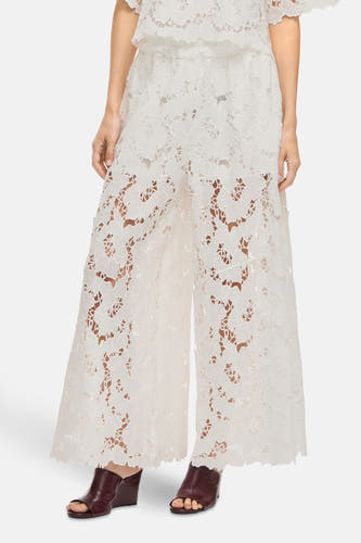 Pantalon blanc de VILA®, avec imprimé floral et larges pinces, associé à des bottines marron à lacets.