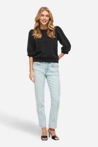 Lichtblauwe straight jeans van VILA, gedragen met een zwarte trui en zwarte hakken.