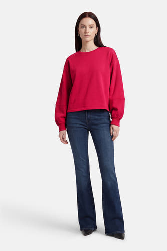 Pull rose à col rond de VILA®, combiné avec un jean foncé à jambes évasées et des chaussures noires.