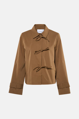Manteau court beige de VILA® avec détail de boutons et manches longues, combiné avec une jupe blanche et des escarpins nude.