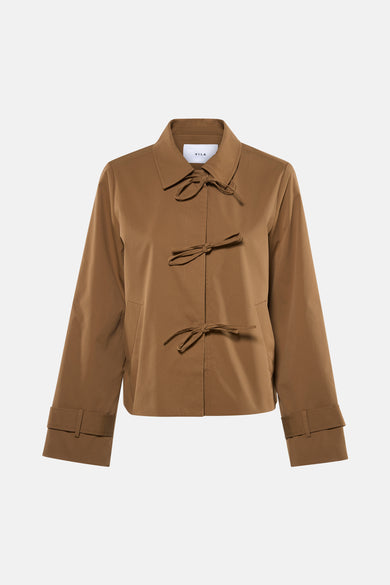 Manteau court beige de VILA® avec détail de boutons et manches longues, combiné avec une jupe blanche et des escarpins nude.