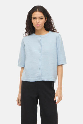 Gilet bleu de VILA®, porté avec un pantalon noir à jambes larges et des talons noirs.