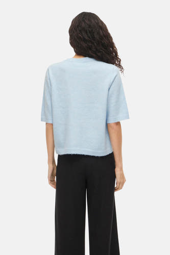 Gilet bleu de VILA à manches courtes, vu de dos, combiné avec un pantalon noir.