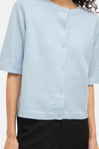 Gilet bleu de VILA® à manches courtes et fermeture boutonnée, porté sur un pantalon noir.