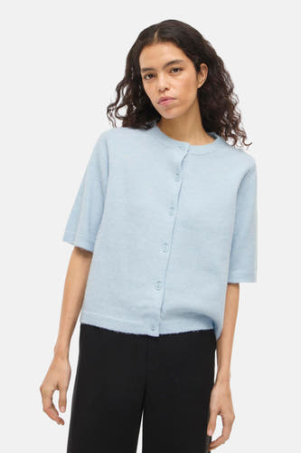 Gilet bleu de VILA® à manches courtes et fermeture boutonnée, porté sur un pantalon noir.