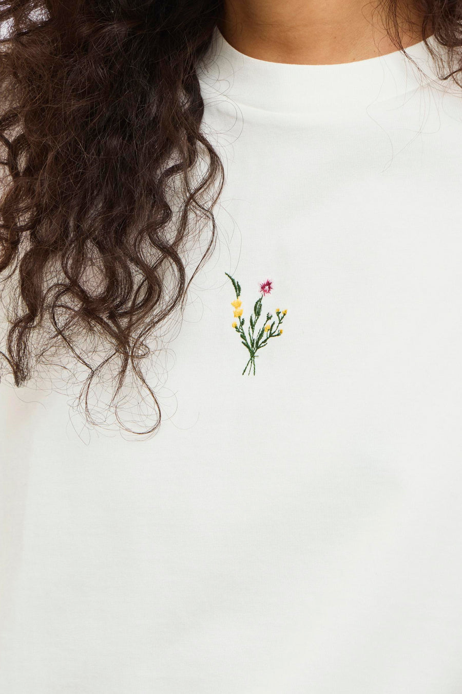 T-shirt blanc VILA®, à manches courtes et avec une petite fleur brodée sur la poitrine.