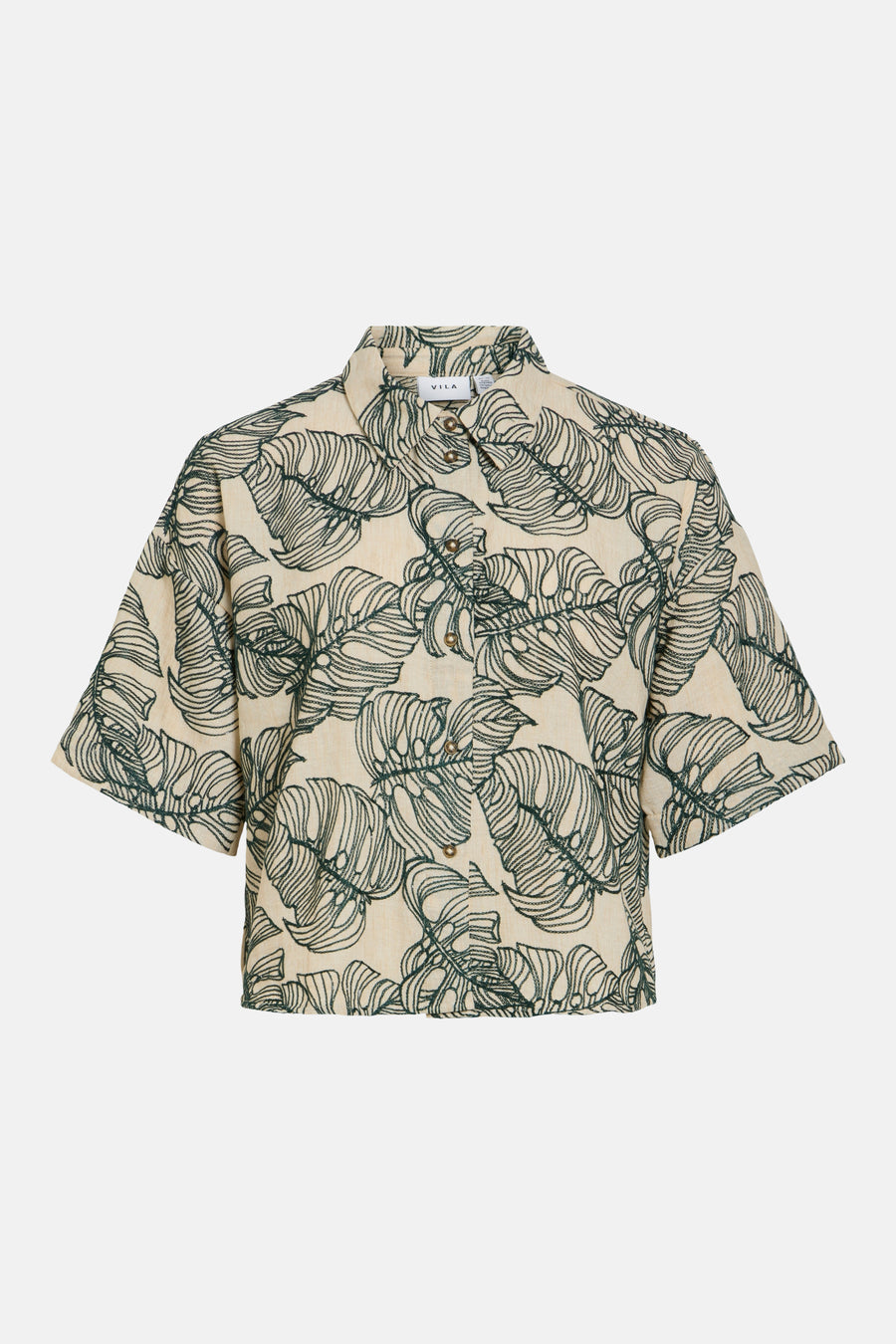 Chemise courte de VILA en blanc cassé avec motif de feuilles de monstera vertes, col rabattu et boutons marron.