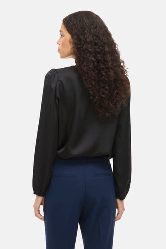 Blouse noire à manches longues de VILA®, vue de derrière avec un pantalon bleu.