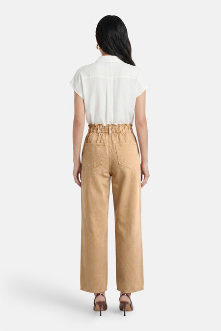 Pantalon marron de VILA avec taille paperbag, jambes larges et poches plaquées au dos, vue de dos, porté avec une chemise blanche et des talons marron.