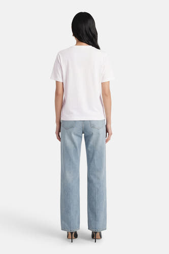 Wit T-shirt met korte mouwen van VILA®, gezien van achteren, gecombineerd met blauwe jeans en zwarte hakken.