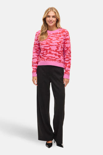 Multikleurige pull met ronde hals van VILA, met roze en rode camouflageprint, gedragen met zwarte pantalon en hakken.
