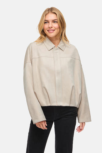 Manteau court beige de VILA®, à manches longues et porté sur une chemise blanche et un jean noir.