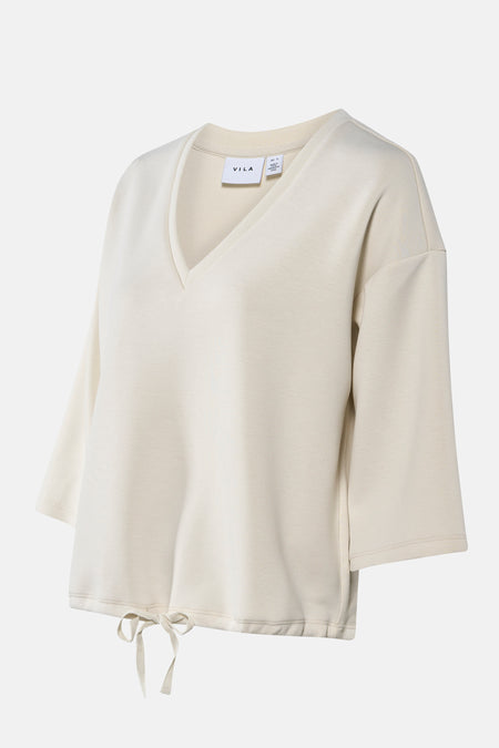 Crèmekleurige VILA trui met V-hals en touwtjes.
