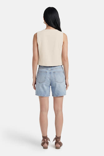 Beige mouwloos gilet van VILA, kort gesneden, gedragen op een denim short met bruine sandalen.