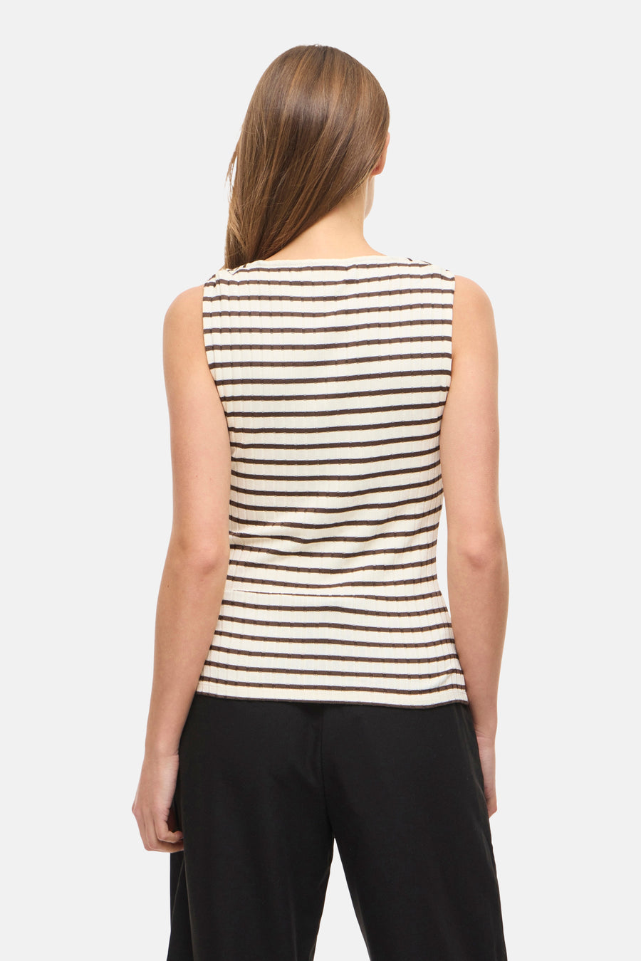 Haut sans manches de couleur blanc cassé à rayures marron de VILA®, en tissu côtelé, vue de dos et associée à un pantalon noir.